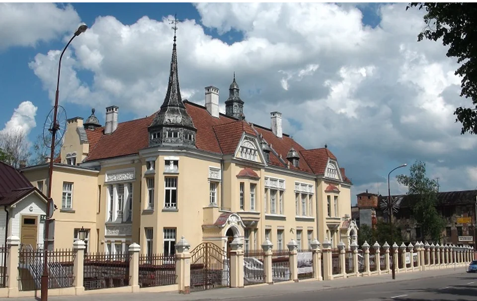 The ornate pale-yellow Frenkel family villa, with red tiled roofs and a tall corner turret.