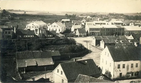 Historic elevated view across rooftops and streets toward the town square in Žagarė.